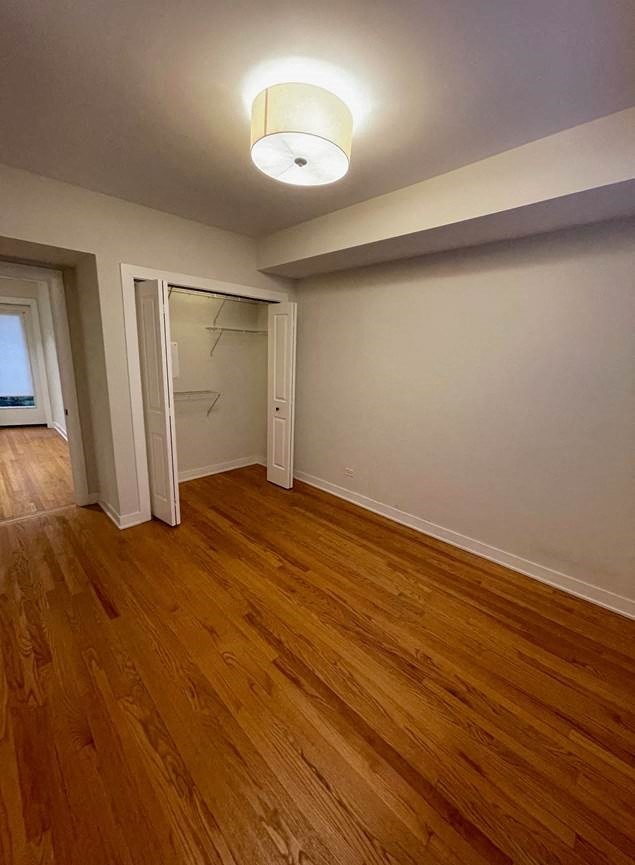 an empty living room with wood floors and a closet
