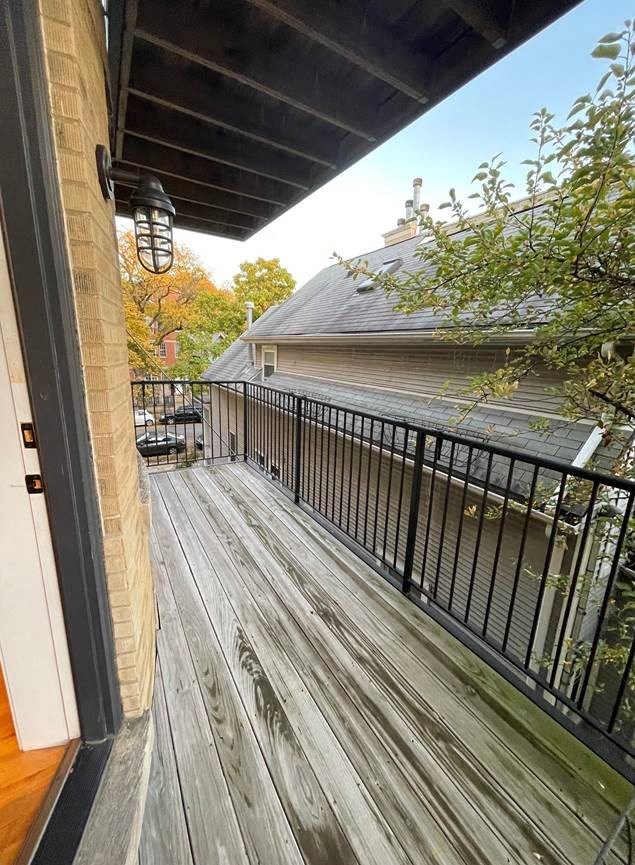 a balcony with a wooden deck next to a building