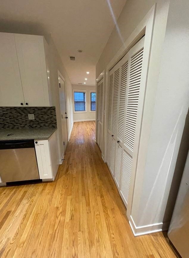 a kitchen and a hallway with a wood floor