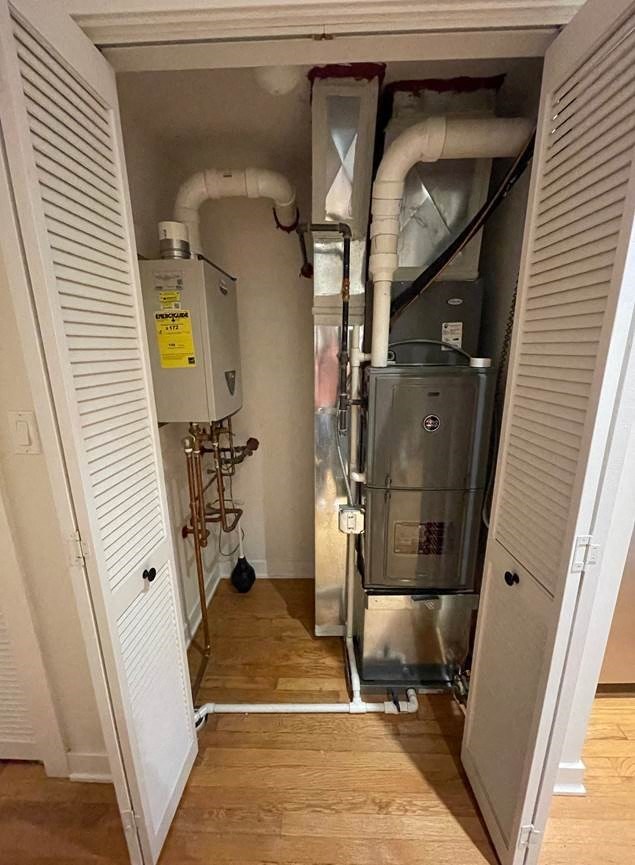 a room with a water heater and pipes in it