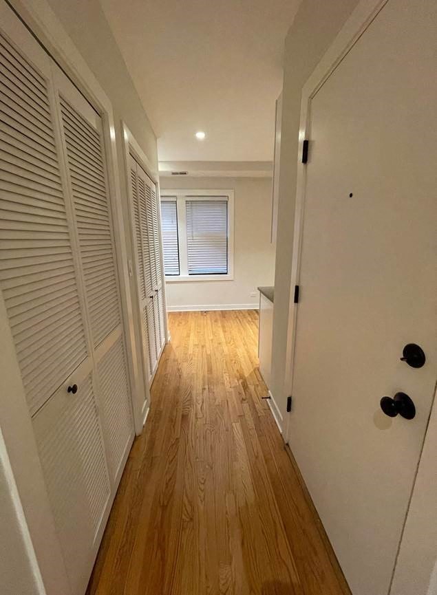 a hallway with a door and a hard wood floor