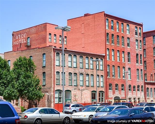 a large brick building with cars parked in a parking lot