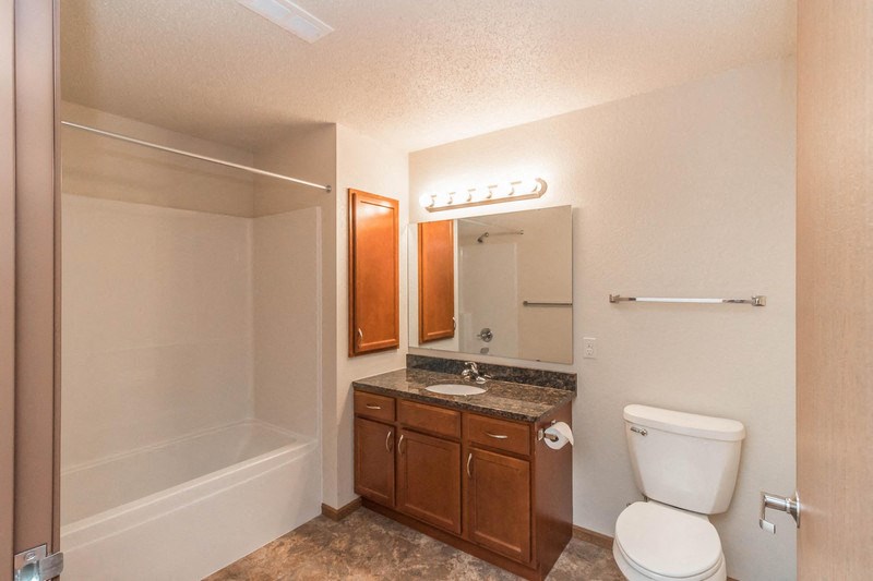 a bathroom with a toilet sink and shower and a mirror