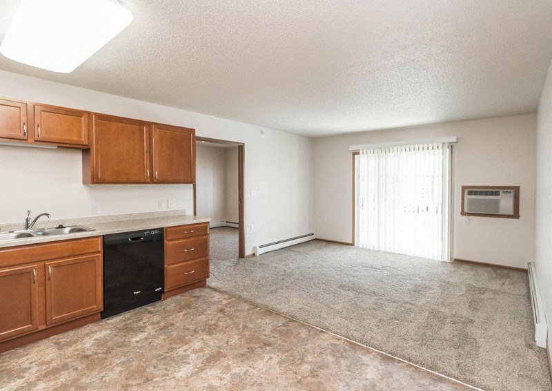 an empty kitchen and living room with a sliding glass door