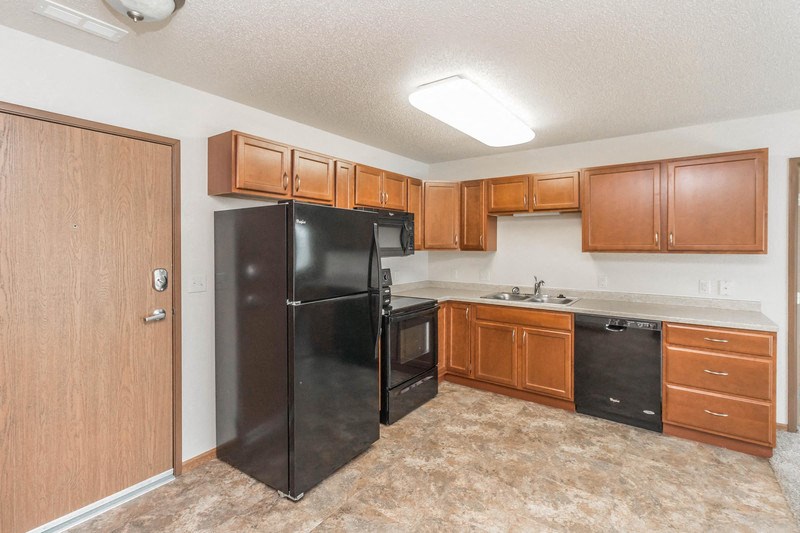 a kitchen with black appliances and wooden cabinets