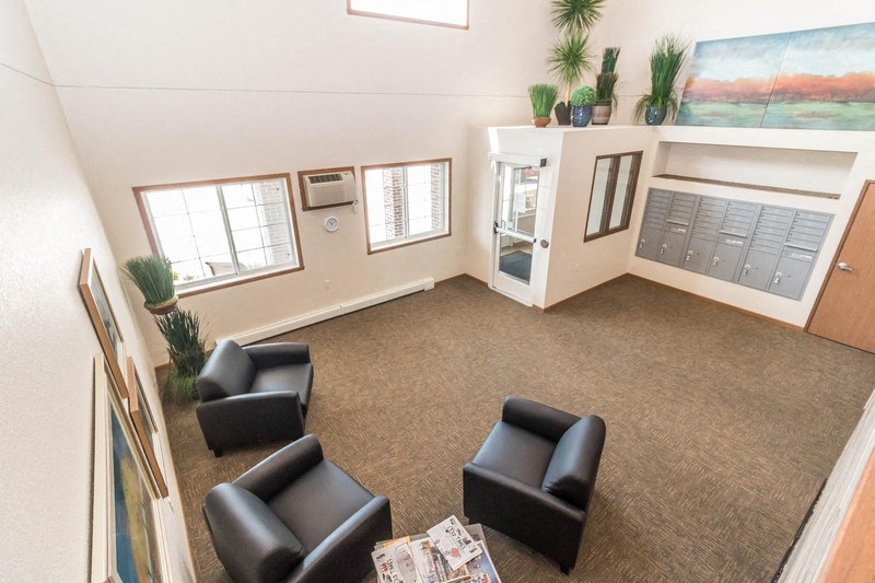 a waiting room at a physicians office with black chairs and a rug