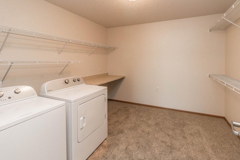 an empty laundry room with two washes and a dryer