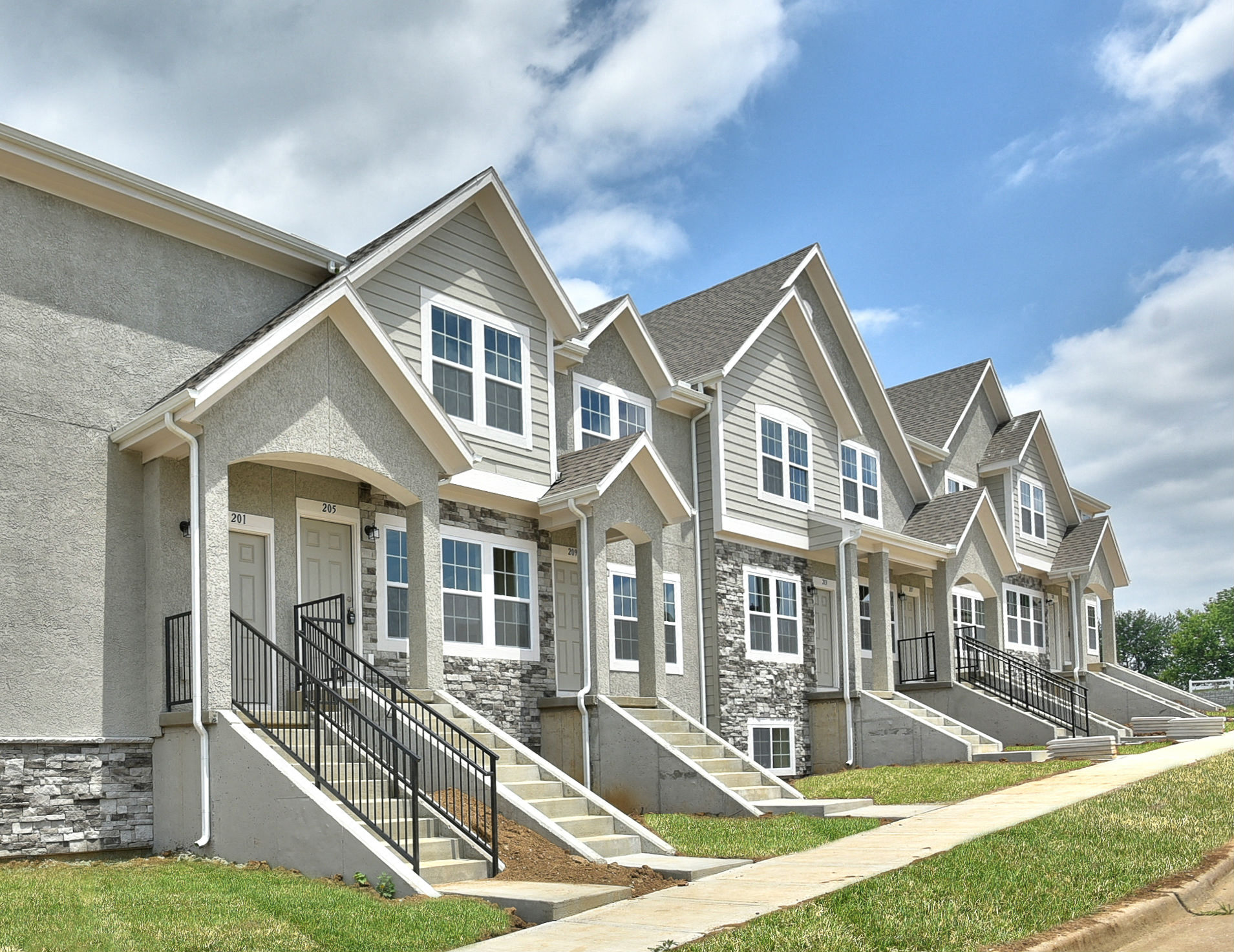 A row of houses with grey siding and white trim.