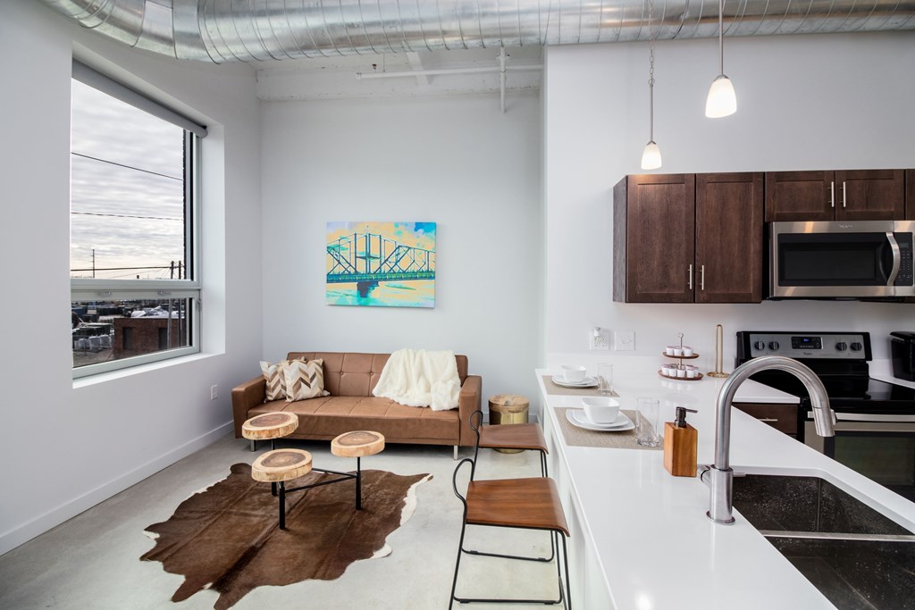a living room with a couch and a kitchen with a sink