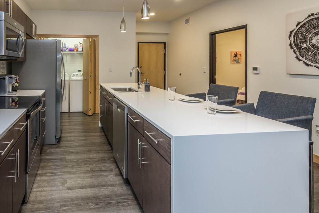 a kitchen with an island and stainless steel appliances and a refrigerator