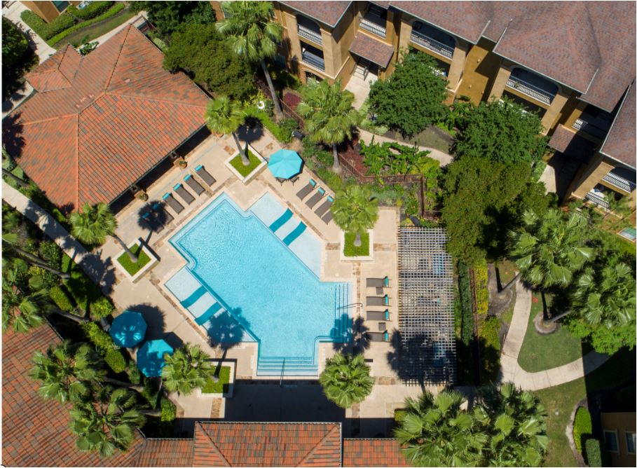 an overhead view of a swimming pool in front of an apartment building