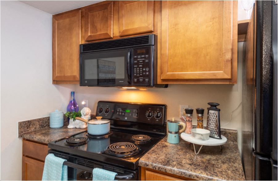 a kitchen with a stove and microwave and wooden cabinets