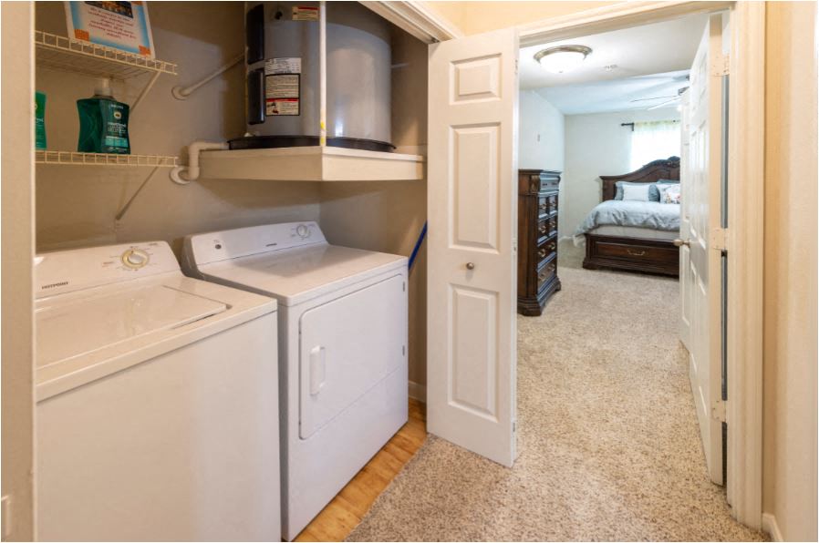 a white washer and dryer in a room with a bedroom
