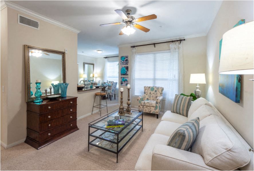 a living room with a white couch and a ceiling fan