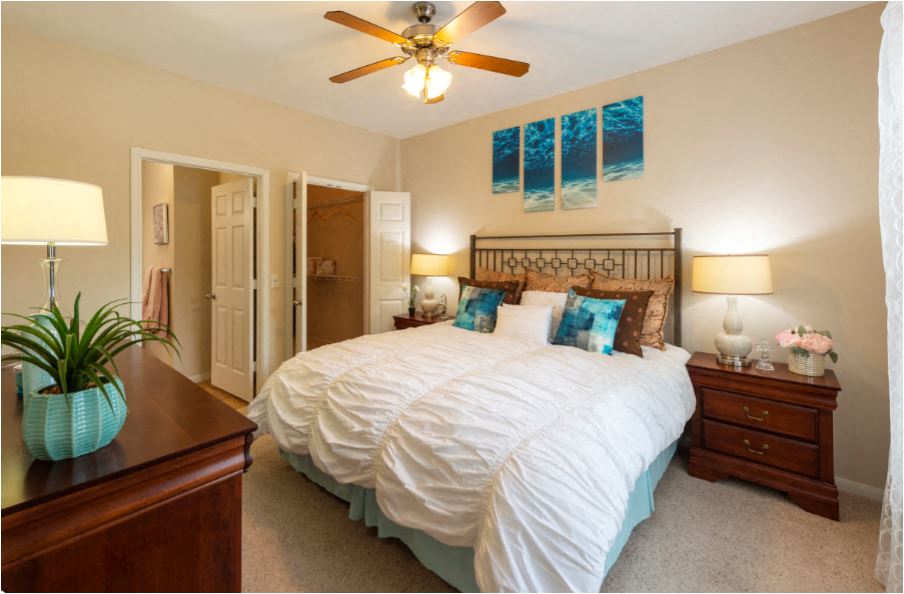 a bedroom with a large bed and a ceiling fan