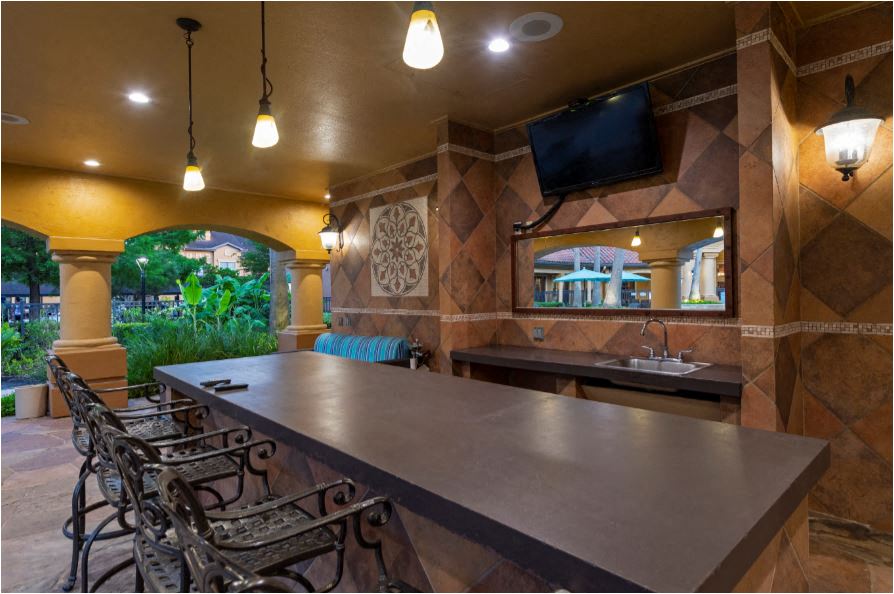 a kitchen with a long bar and a television