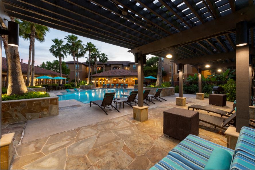 a swimming pool with lounge chairs and a covered patio
