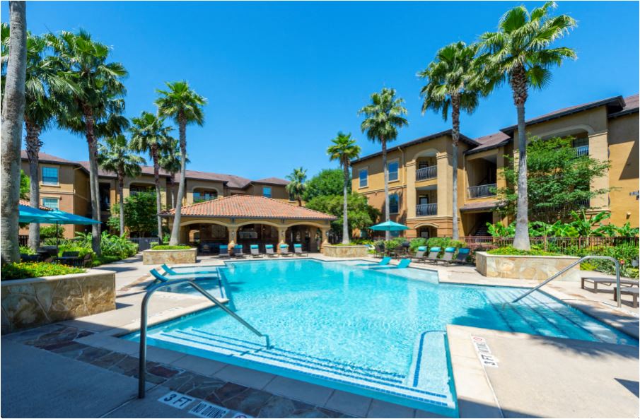 a swimming pool with palm trees and buildings in the background