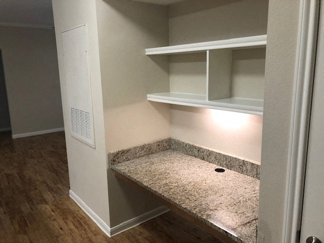 an empty bathroom with a counter and shelves