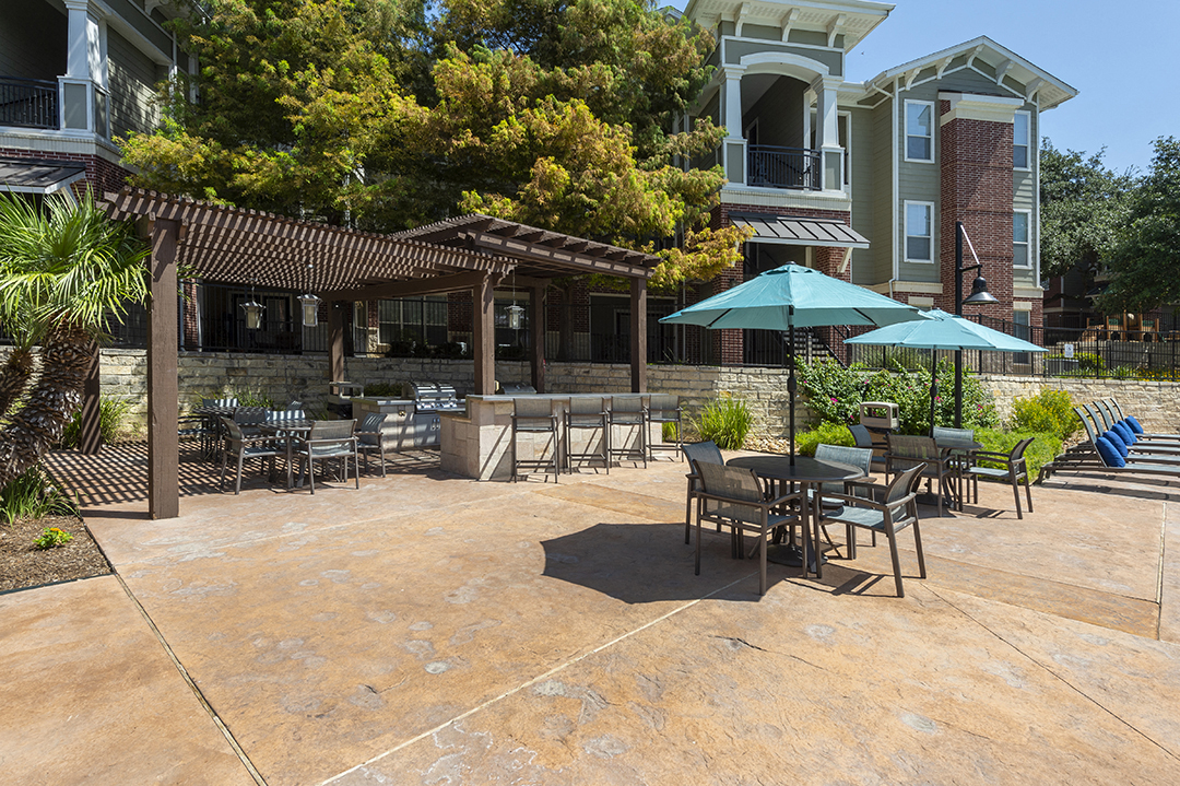a patio with tables and chairs and umbrellas