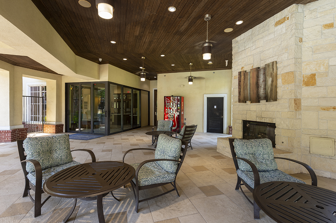 a patio with tables and chairs and a fireplace
