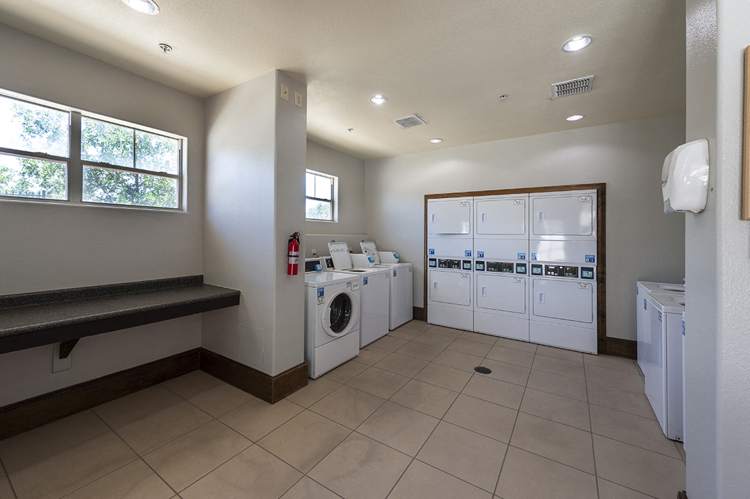 a laundry room with washers and dryers and a counter with a washer