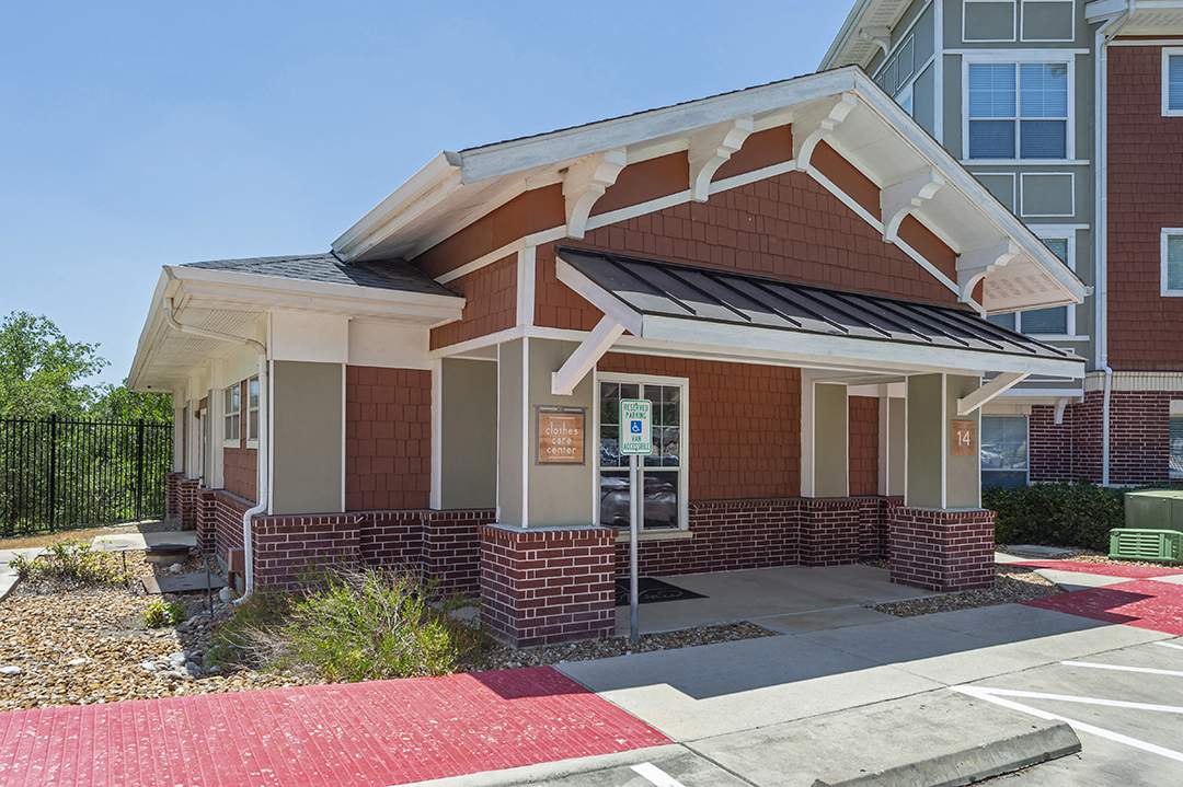 a small brick building with a porch and a sign on the door