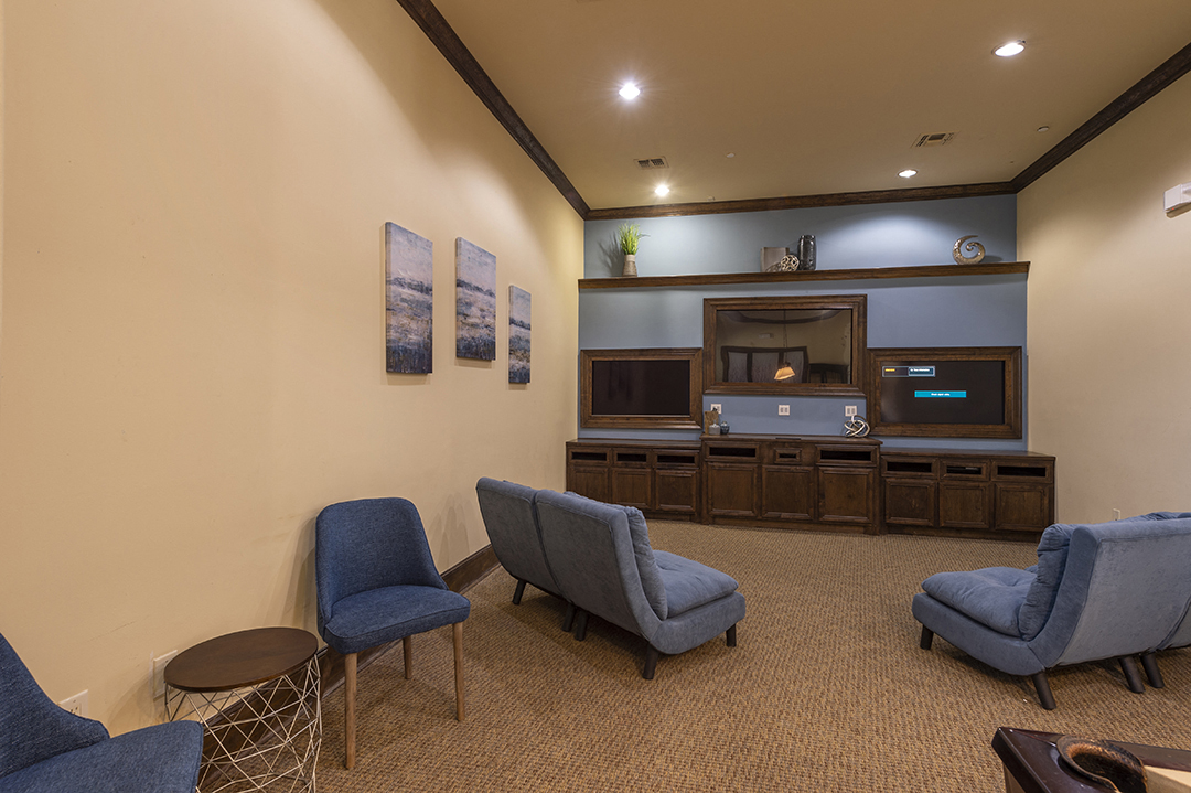 a living room with blue chairs and a television
