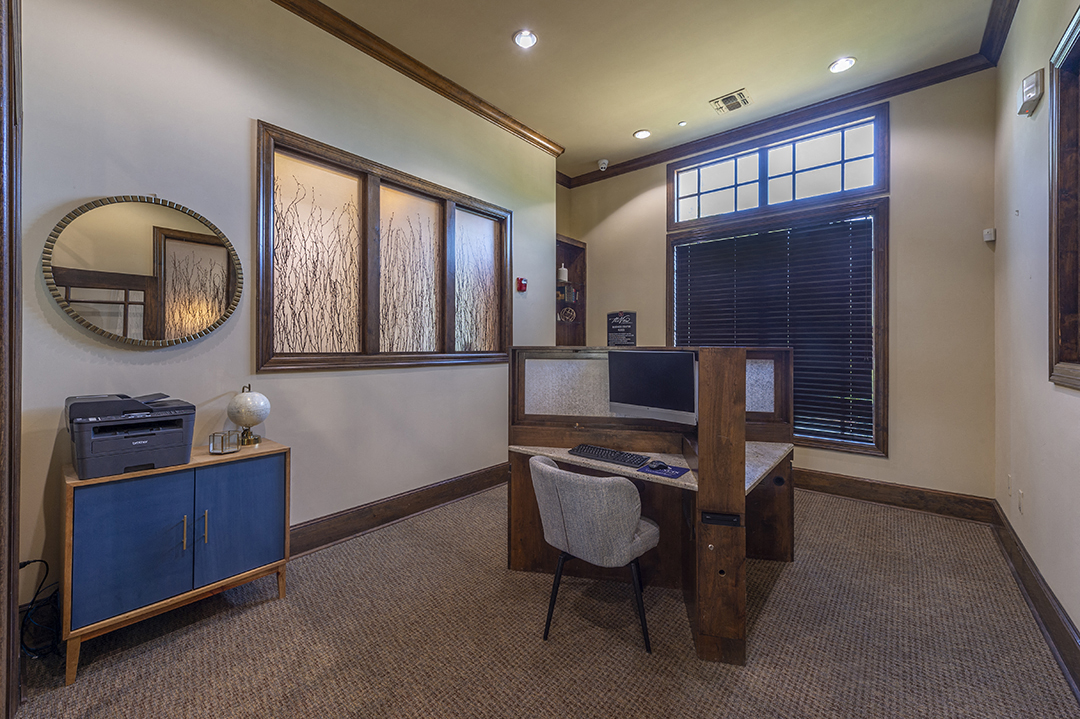 a home office with a desk and a chair and a window