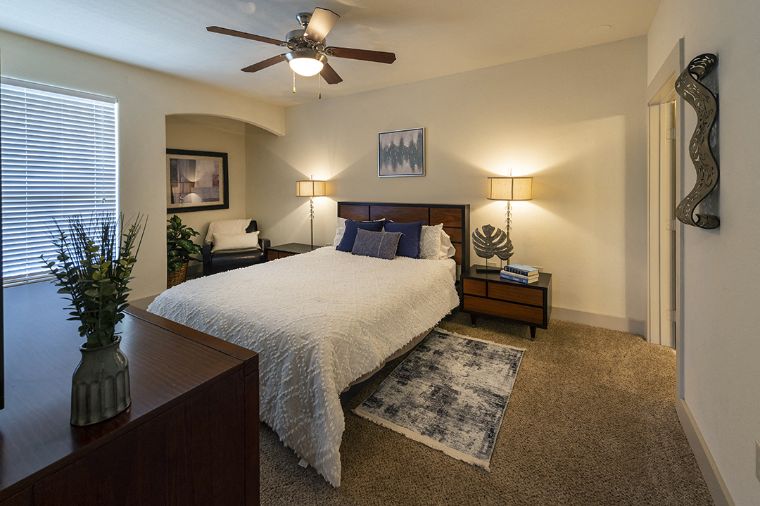 a bedroom with a large bed and a ceiling fan