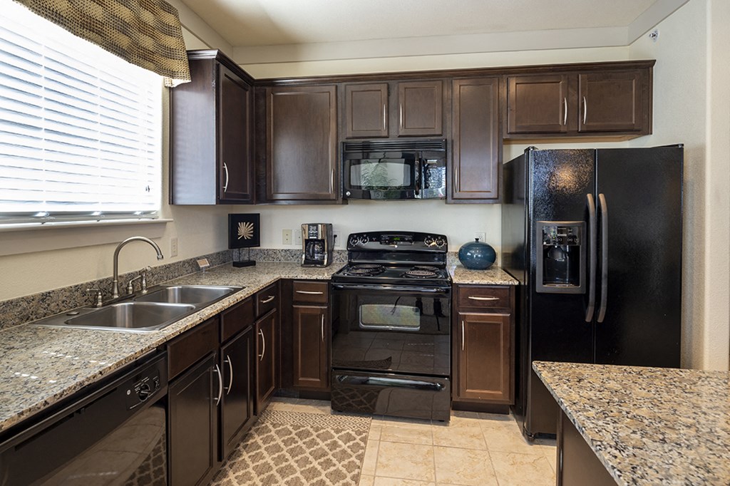 a kitchen with black appliances and granite counter tops