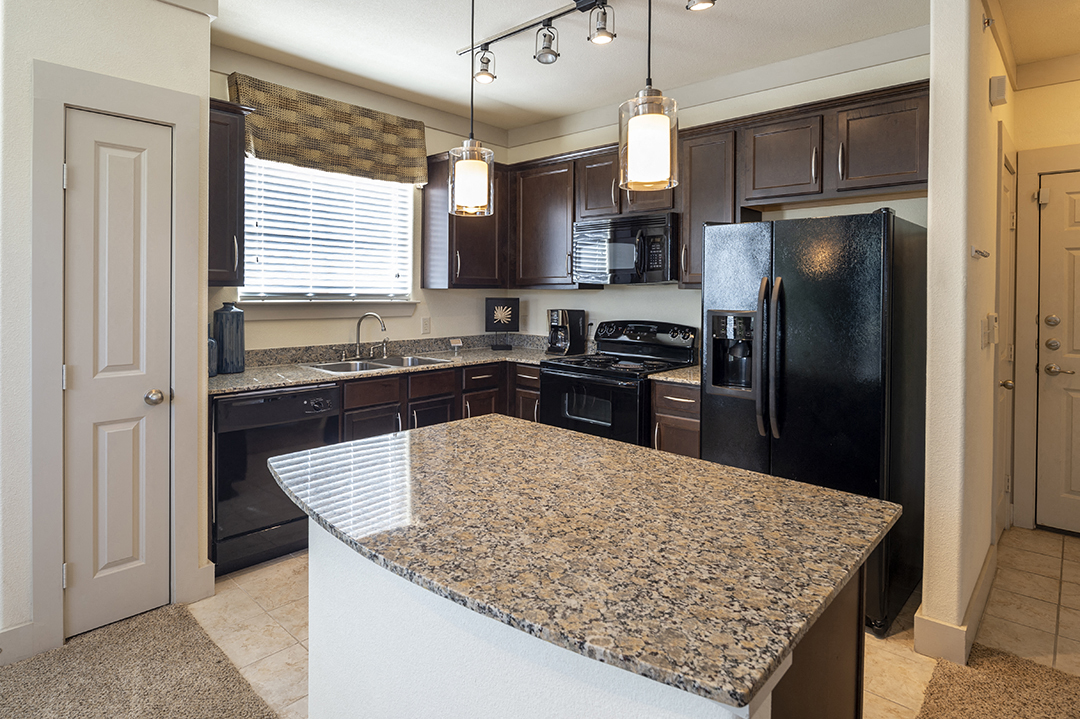 a kitchen with black appliances and granite counter tops
