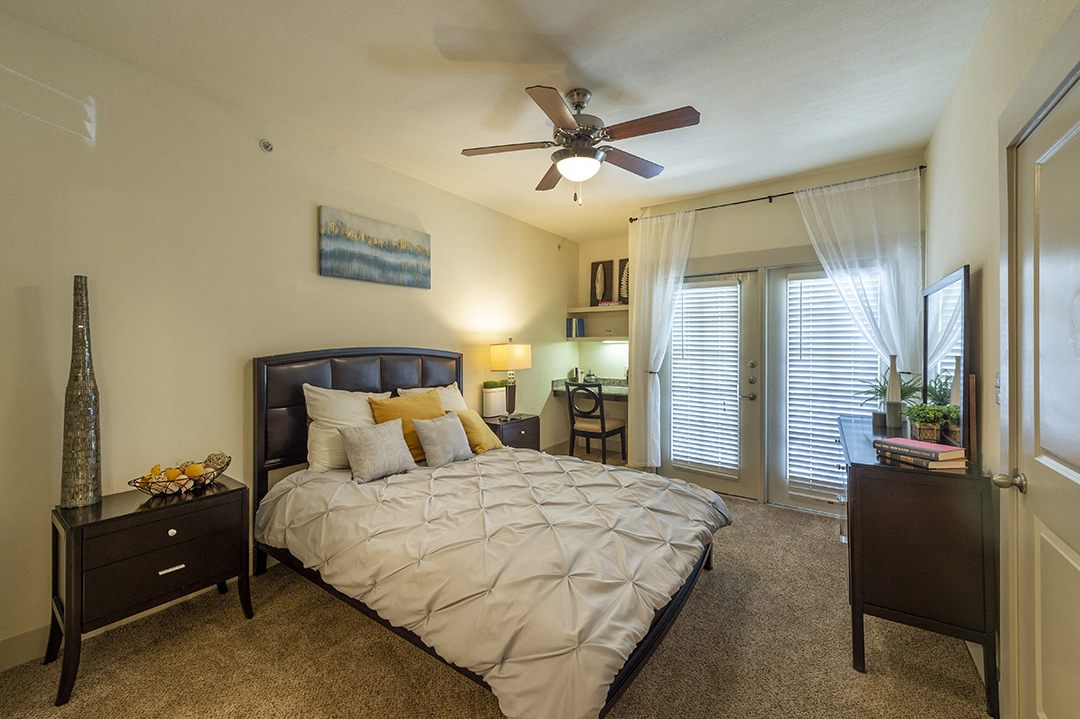 a bedroom with a large bed and a ceiling fan