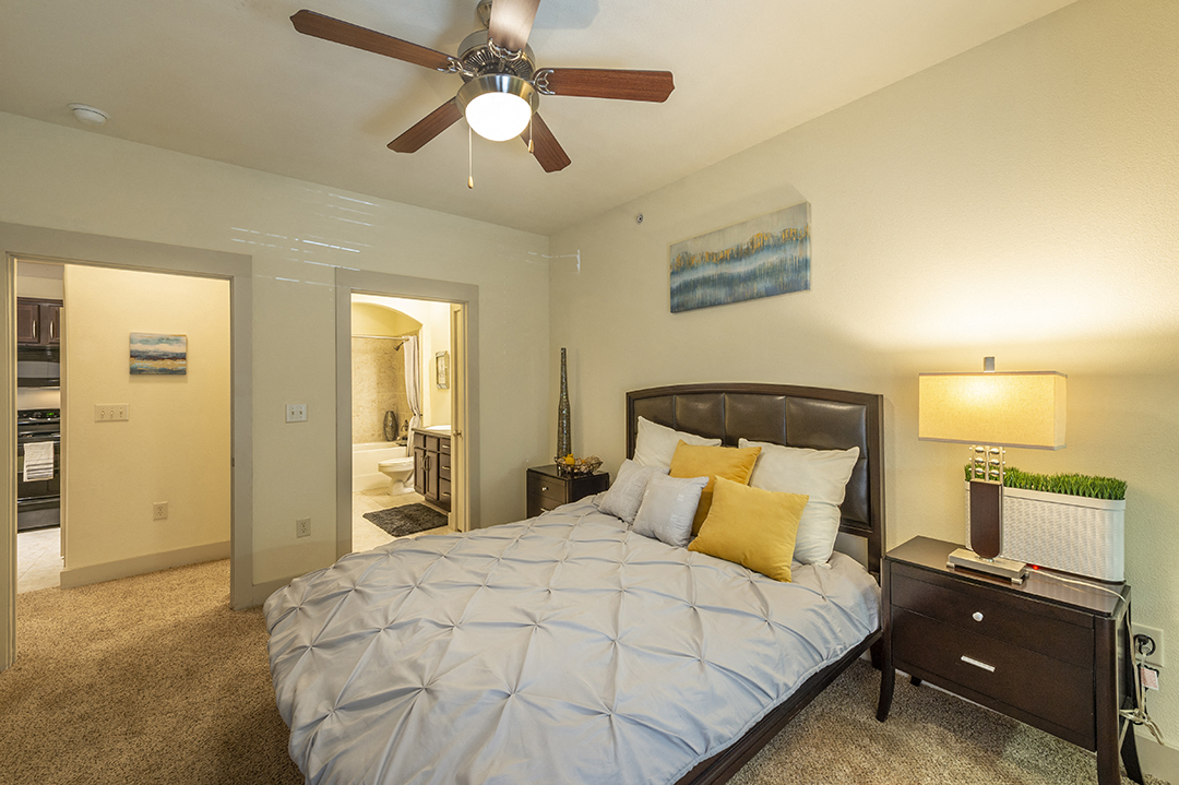 a bedroom with a large bed and a ceiling fan