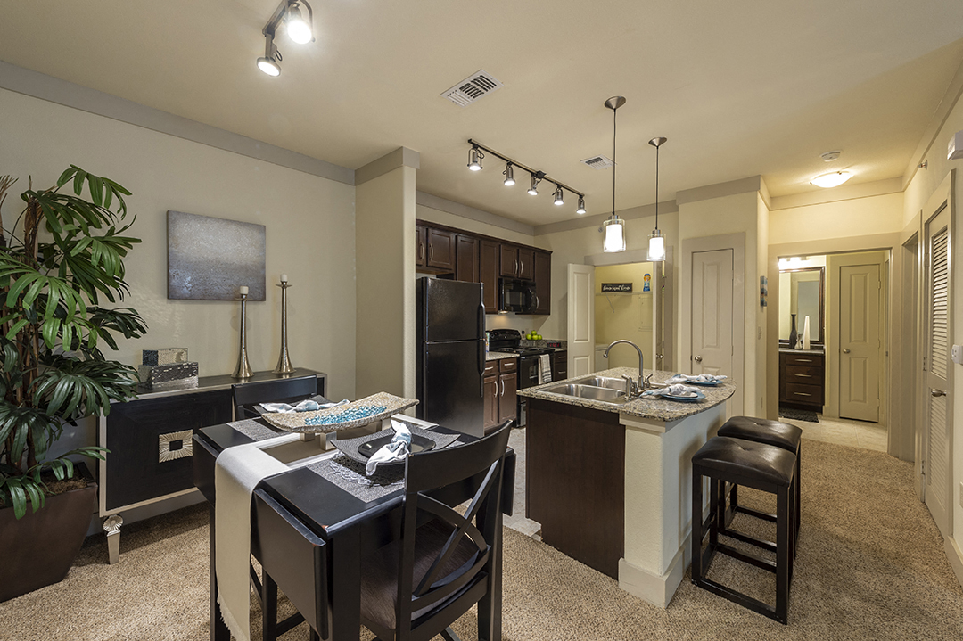 a kitchen and dining room with a bar and a table with chairs
