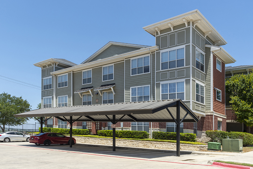 an apartment building with a carport in front of it