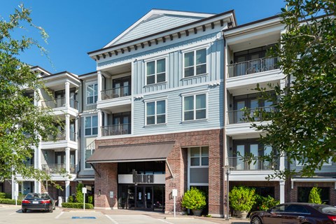 A large apartment building with a blue facade and a brick entrance.