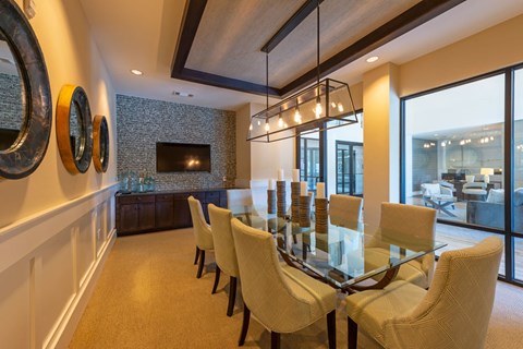 A dining room with a glass table and chairs.