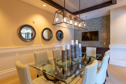 A glass dining table with chairs and a wall-mounted mirror.