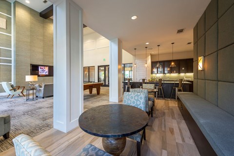 A living room with a black table in the middle.