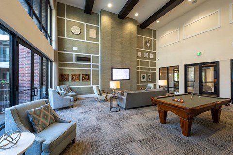 A large room with a pool table and couches.