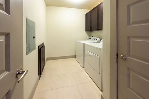 A kitchen area with a white stove top oven and a white dishwasher.