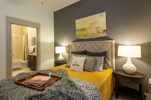 A bedroom with a bed, nightstand, and lamp.