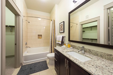 A bathroom with a white tub, sink, and toilet.