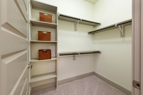 A white closet with shelves and a basket.