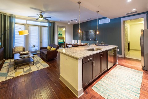 A modern kitchen with a large island and a ceiling fan.
