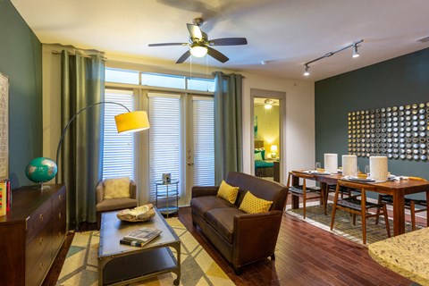 A living room with a brown couch and a ceiling fan.