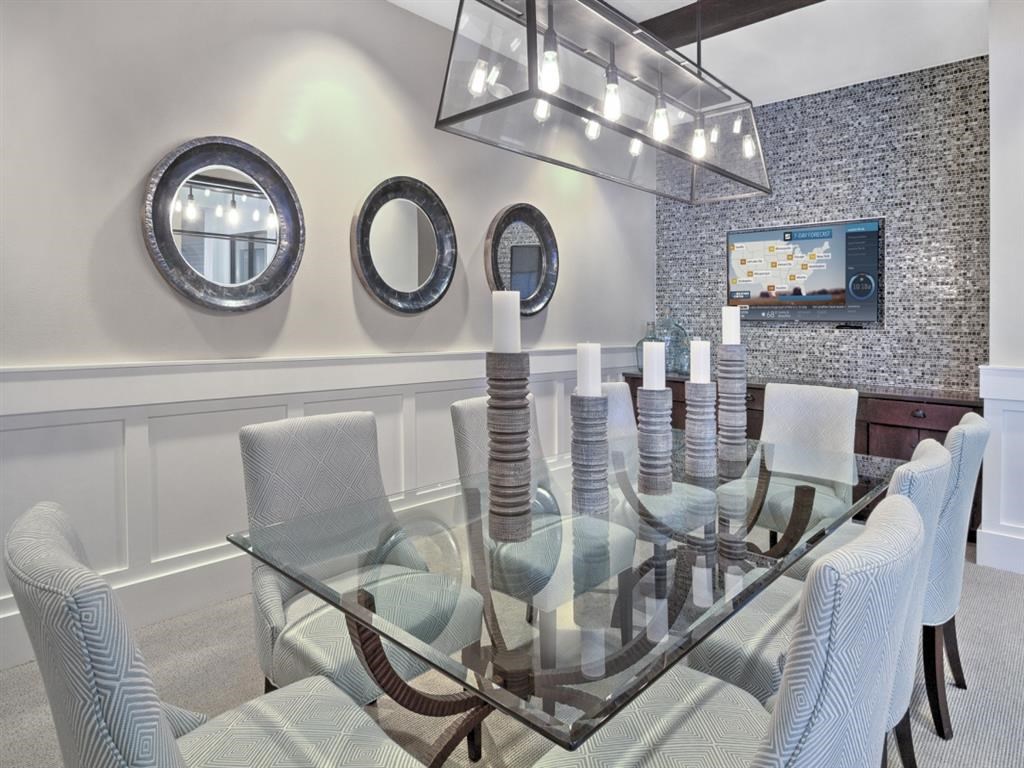 a dining room with a glass table and chairs