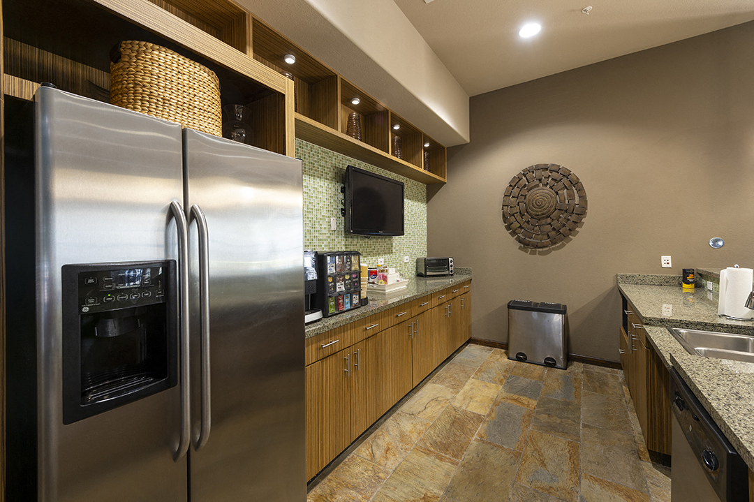 A modern kitchen with a stainless steel refrigerator and wooden cabinets.