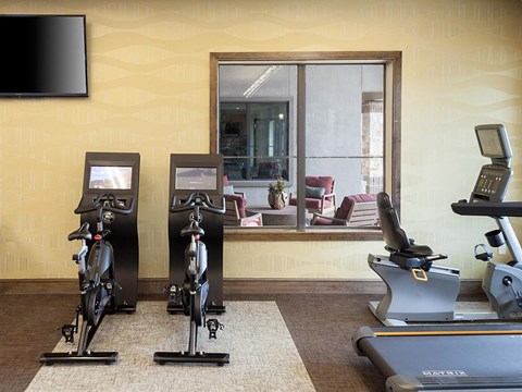 a gym with exercise equipment and a large window